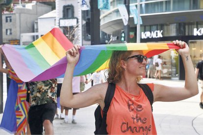 Una participant en la marxa sostenint la bandera LGTBIQ+.