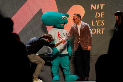 El presentador català de la gala, Quim Masferrer, saludant Xavier Espot, i darrere seu, una mascota