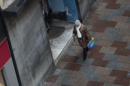 Una vianant amb un bastó, passejant per l'avinguda Carlemany aquest matí.