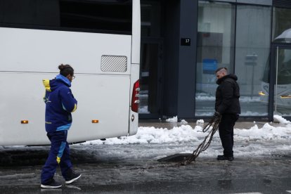 El conductor d'un autobús estranger posant cadenes a Escaldes