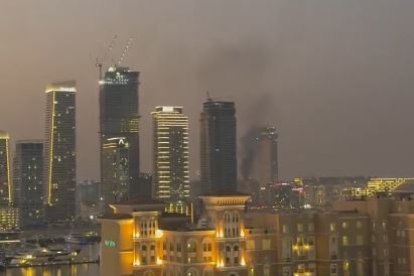 Fum en un edifci al centre de Dubai després de l’impacte de restes d’un projectil iranià.