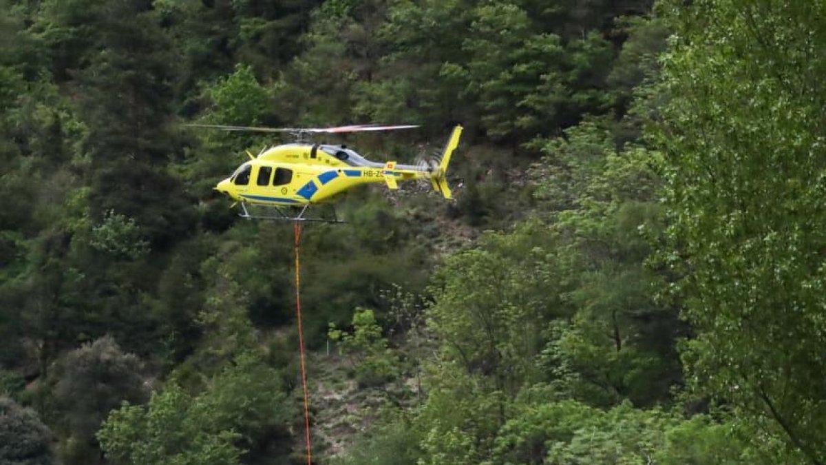 Un helicòpter treu el cos de la víctima del riu.