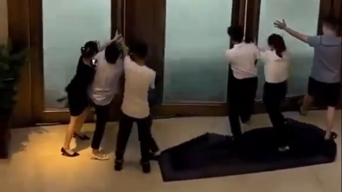 Un grup de treballadors intentant tancar les portes d'un hotel