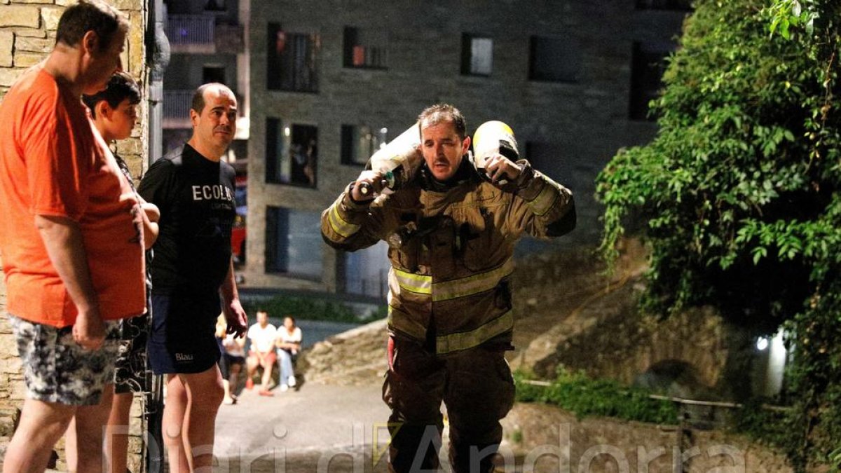 Un bomber carregat amb bombones per arribar a l'edifici de l'incendi a Escaldes