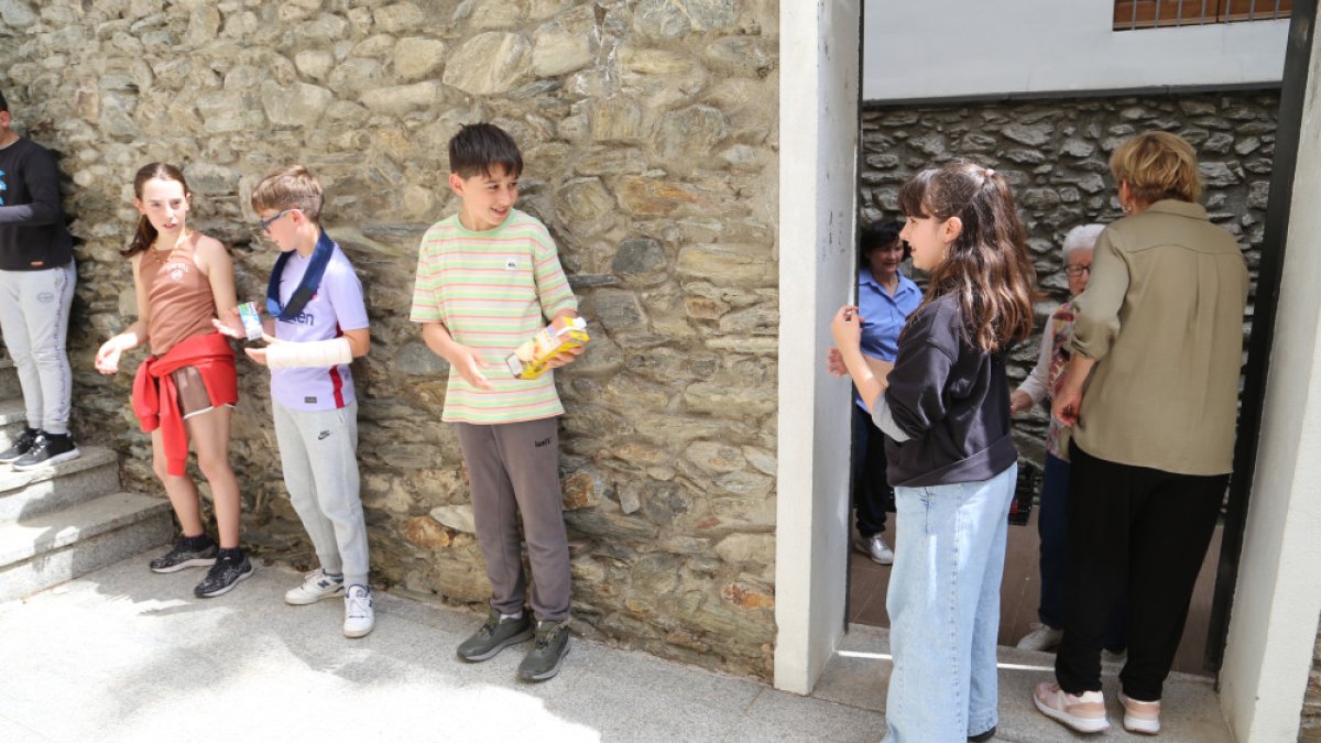 Escolars lauredians de la cadena de recollida d'aliments ahir a Santa Julià