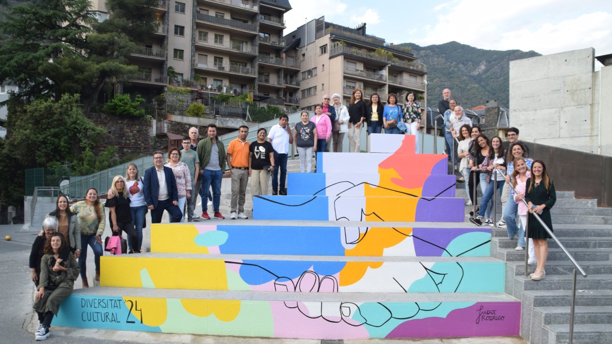 La cònsol menor d'Andorra la Vella, Olalla Losada, l'artista Judit Rodrigo, i totes les associacions participants en la creació del mural de la Setmana de la Diversitat Cultural 2024.