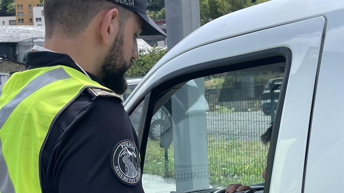 Un agent de policia fent un control d'alcoholèmia a un conductor