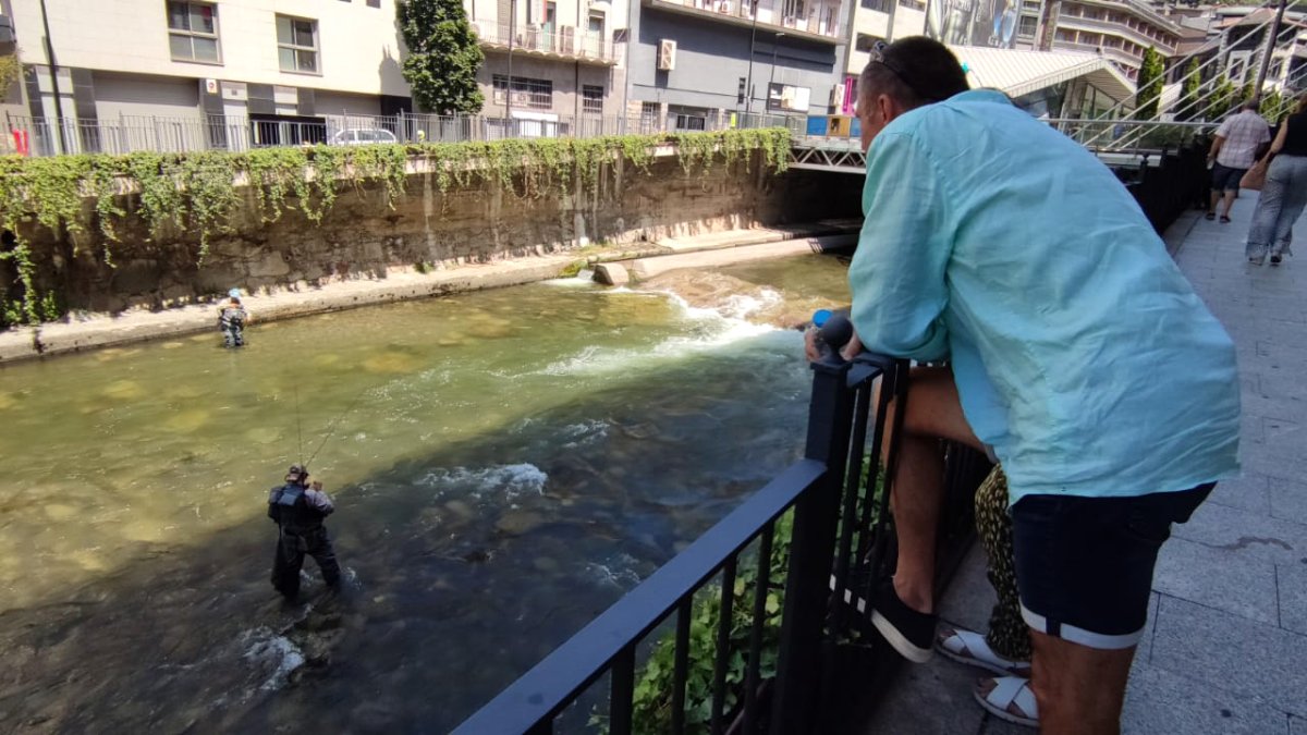 Uns turistes contemplant un parell de pescadors a la capital, ahir.