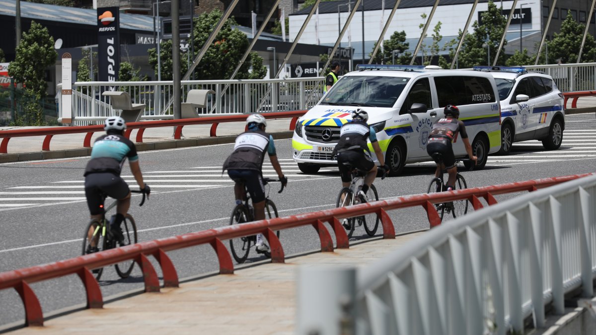 Dos vehicles de la policia i uns ciclistes.