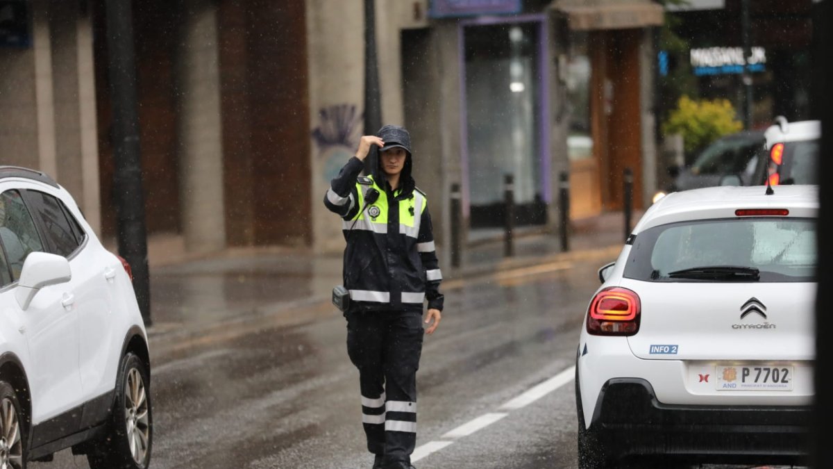 La policia dirigint el trànsit aquest matí a la Massana quan ha començat a ploure