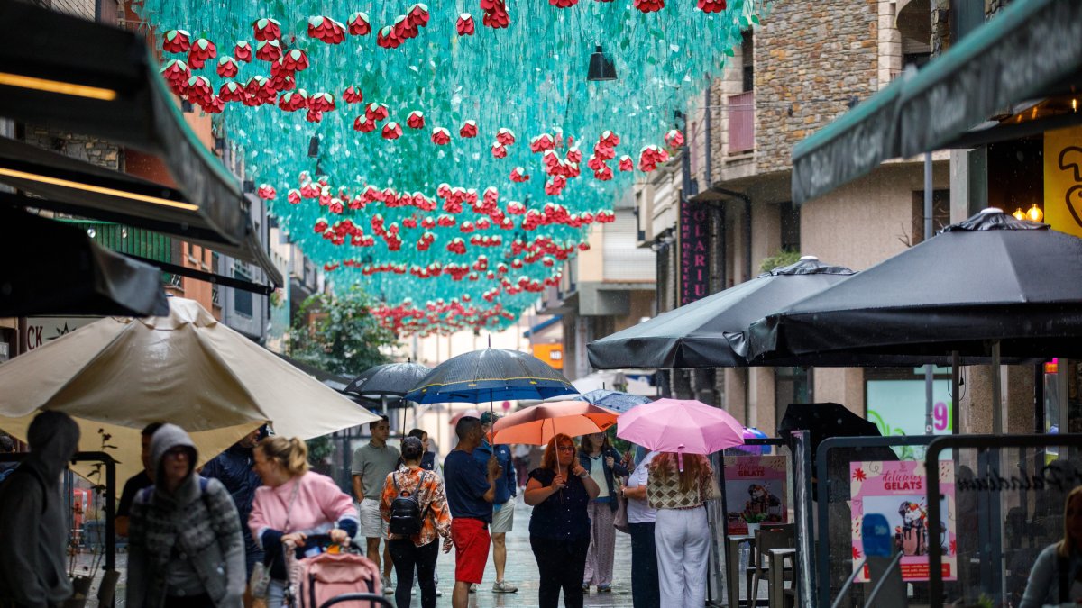 Turistes buscant restaurant sota la pluja la tarda d’ahir.