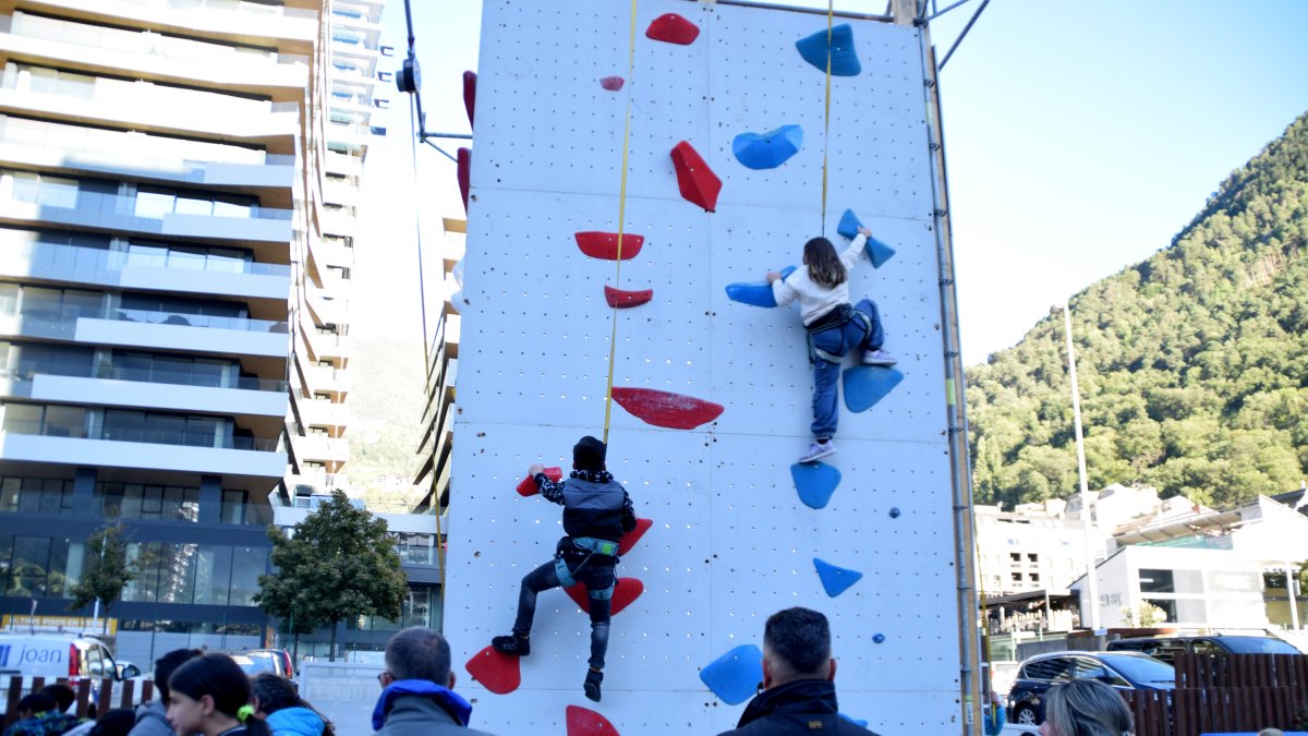 Dos joves escaladors escalant en el rocòdrom.