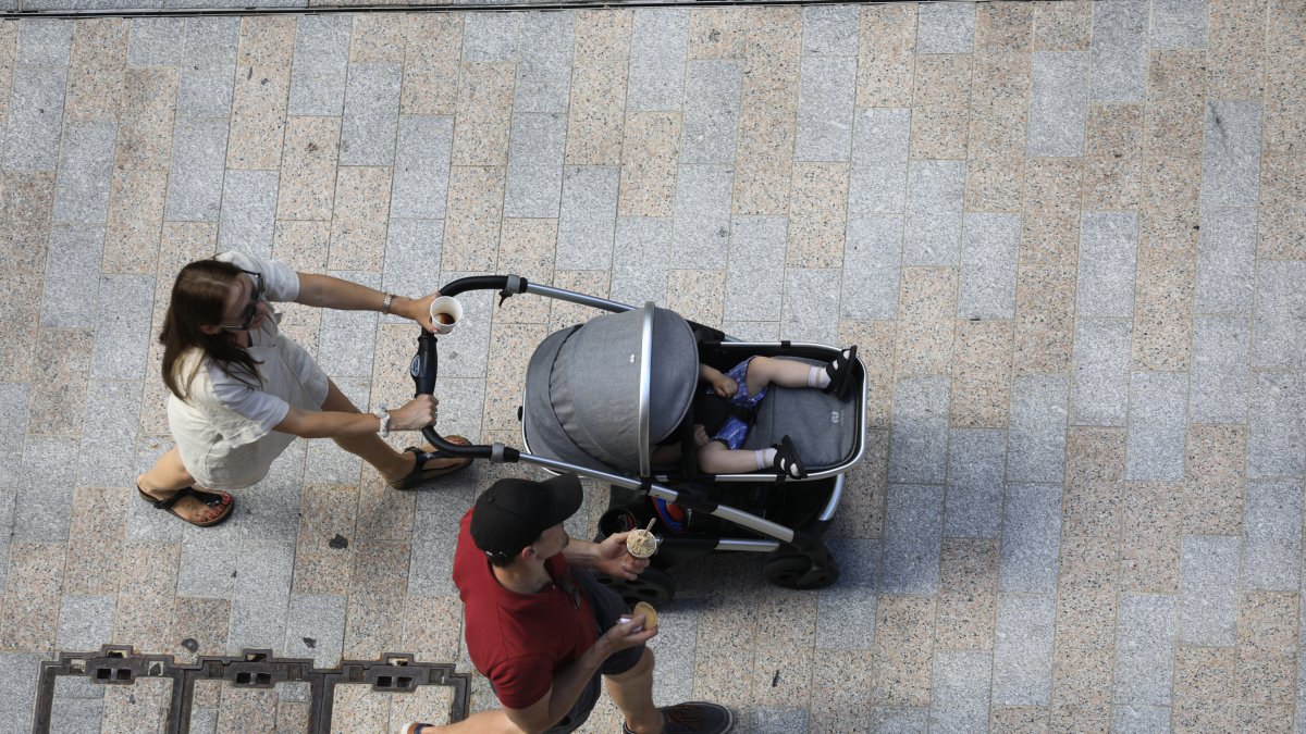 Una dona passejant amb el seu nadó.