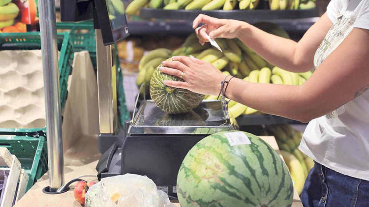 Una dona comprant fruita en un establiment.