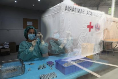 Sanitàries preparant dosis de Pfizer al centre de vacunació de la plaça de braus