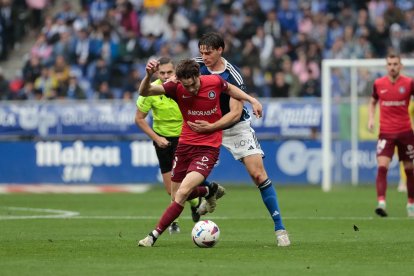 Jandro Orellana lluita per una pilota davant un jugador de l'Oviedo