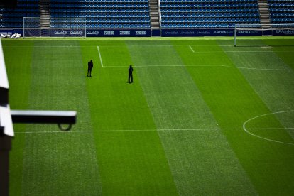 Dos jardiners treballant ahir sobre la superfície natural de l’Estadi Nacional.