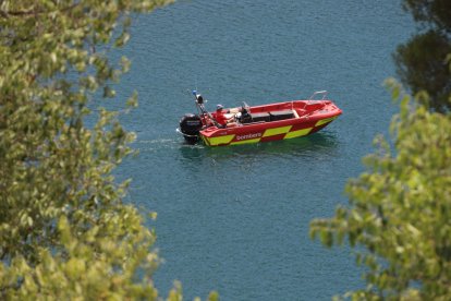 Bombers treballant en la recerca del menor desaparegut al pantà