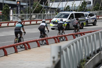 Dos vehicles de la policia i uns ciclistes.