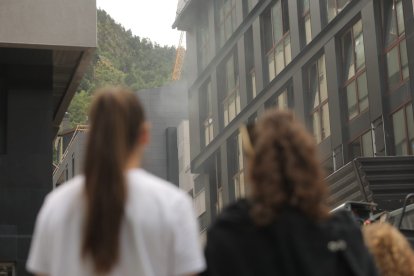 Dues dones observen el fum que surt de l'edifici de l'incendi a l'avinguda Carlemany