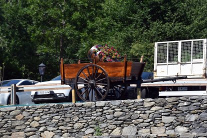 Un carro i un barril de vi decorats amb flors, a Llorts.