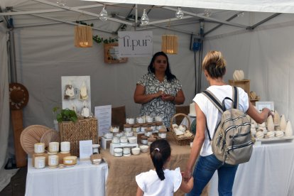 Unes clientes visitant una de les parades del mercat artesanal d'Ordino.