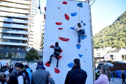 Dos joves escaladors escalant en el rocòdrom.