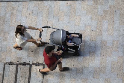 Una dona passejant amb el seu nadó.