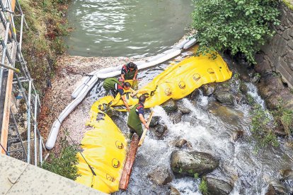 Operaris treballant en el vessament d'hidrocarburs al pont de la Tosca