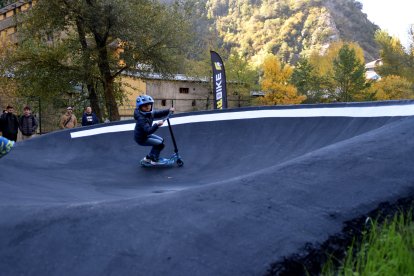 Un nen amb un patinet estranant el pump track