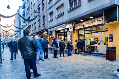 Clients fent cua davant de l'administració de loteria 'Fil d'Or Can Naudi'.