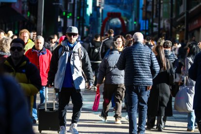 Un turista caminant per l’avinguda Meritxell amb l’equipatge.