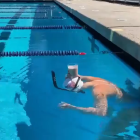 La nedadora Katie Ledecky creua una piscina amb un got de llet al cap