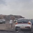 Es baixa del cotxe enmig de la carretera