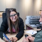 Una treballadora de Tràmits mostra el funcionament de la nova app a un ciutadà.