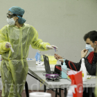 Dos membres de la Creu Roja preparen un test TMA