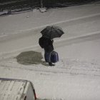 Un vianant protegint-se de la neu.