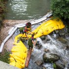 Equips de neteja treballant al riu Madriu per controlar el vessament.