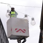 Un operari del comú penjant garlandes de Nadal.