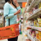 Una dona amb productes d’alimentació a la cistella.