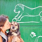 Una dona abraçant un gos.