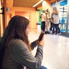 Una estudiant amb un telèfon mòbil.