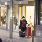 Una dona carrega dues maletes a la part alta d’Escaldes.