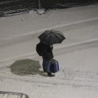 Un vianant protegint-se de la neu.