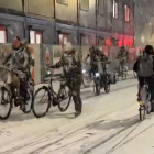 Ciclistes circulant amb bici sobre el terra tot nevat a Brusel·les.