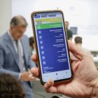 El ministre Rossell, al fons, fent servir la cartera digital.