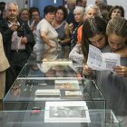 Diverses persones en una exposició sobre la col·lecció de bíblies del Santuari Meritxell d'Andorra.