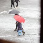 Dues persones caminant sota la neu.