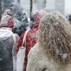Diversos usuaris esperant el bus al Pas de la Casa sorpresos per la neu.