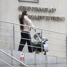 Una dona i el seu nadó surten del Servei d’Immigració.